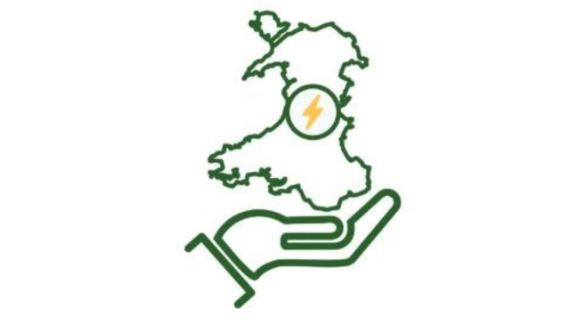 ~Llaw yn dal map o Gymru gyda bolt trydan tu fewn iddi